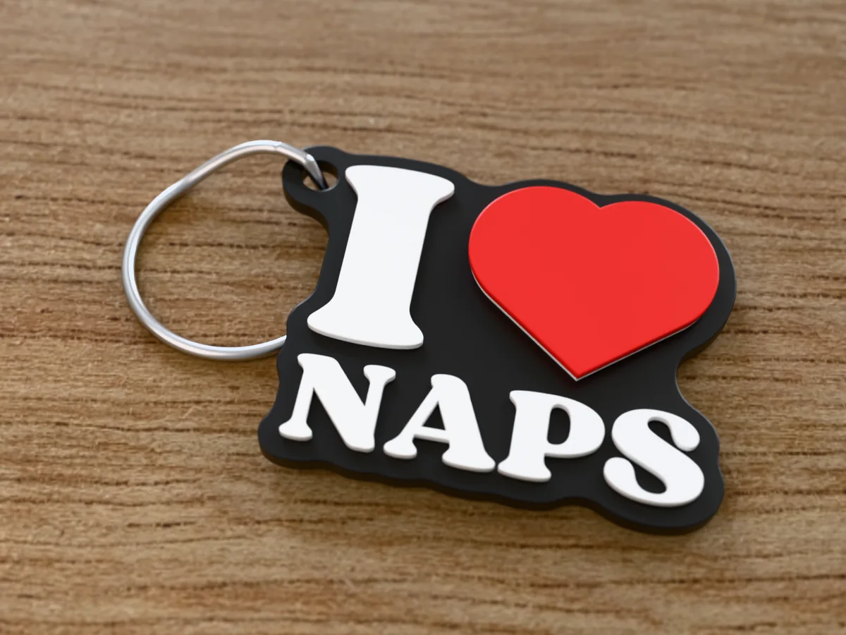 3D render of a black, white and red 3D-printed I love naps keychain with a steel split ring through its hole