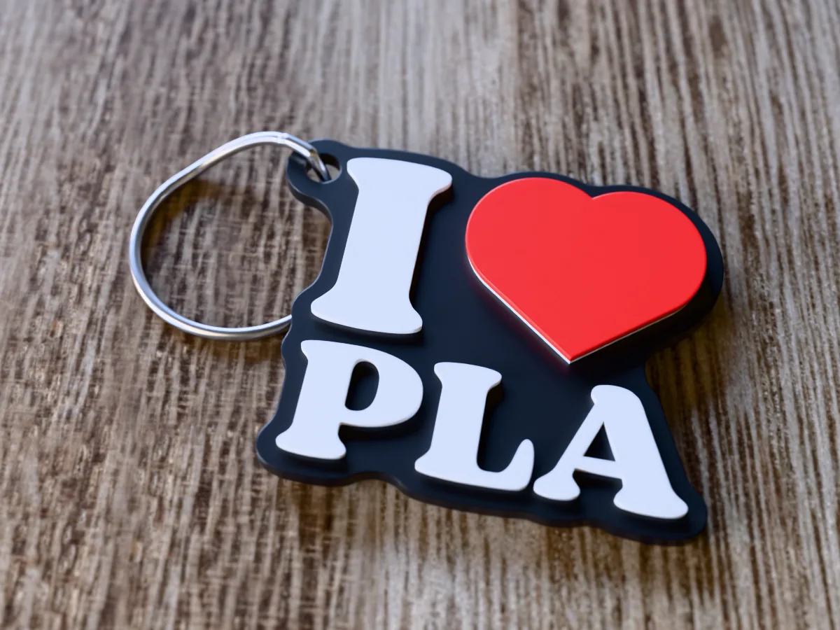 3D render of a black, white and red 3D-printed I love PLA keychain with a steel split ring through its hole