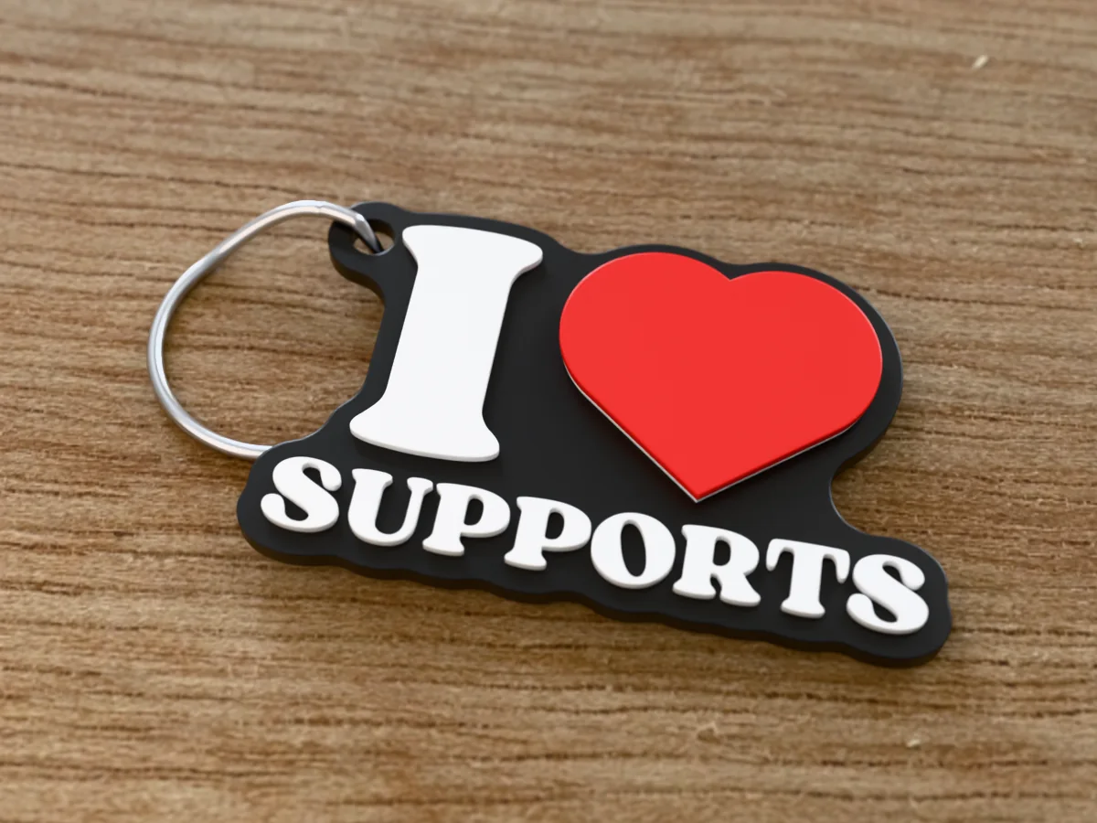 3D render of a black, white and red 3D-printed I love supports keychain with a steel split ring through its hole