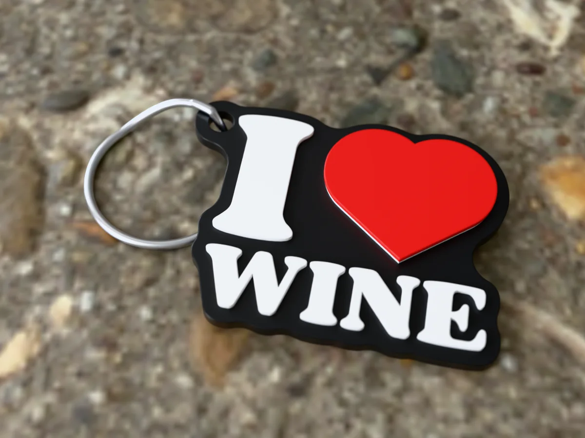3D render of a black, white and red 3D-printed I love wine keychain with a steel split ring through its hole