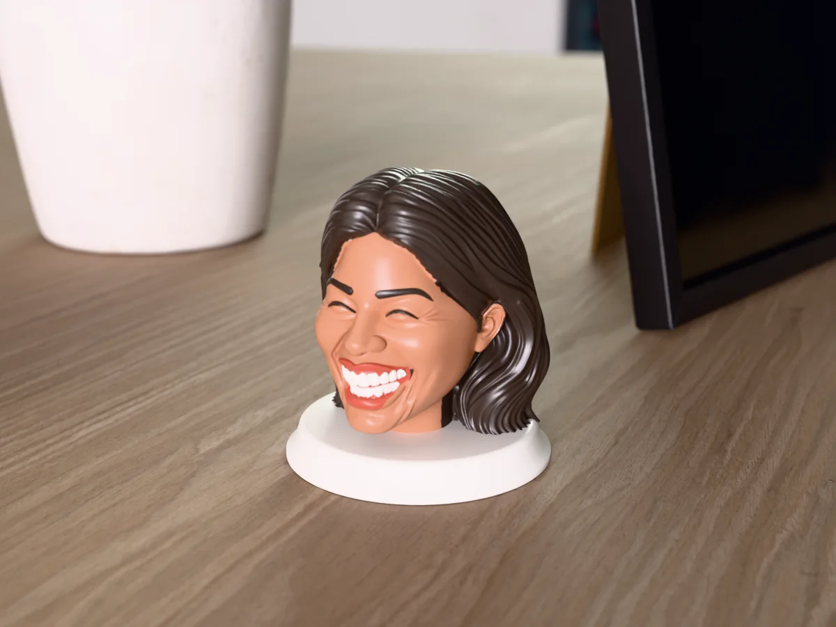 3D render of a 3D-printed bust of a woman with long dark hair, laughing with her eyes shut, painted in 6 colours, on a table