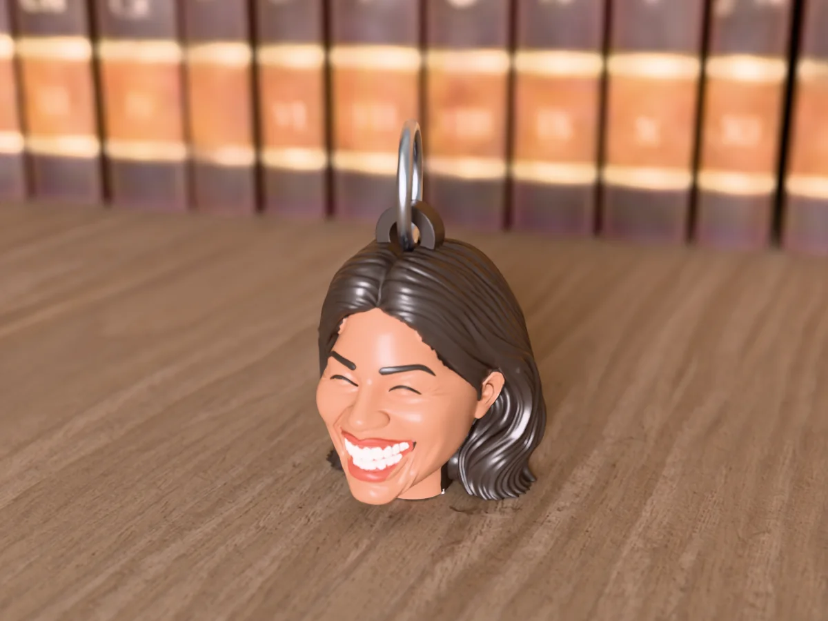 3D render of a 3D-printed head keychain of a woman with long dark hair, laughing with her eyes shut, painted in 6 colours, on a table