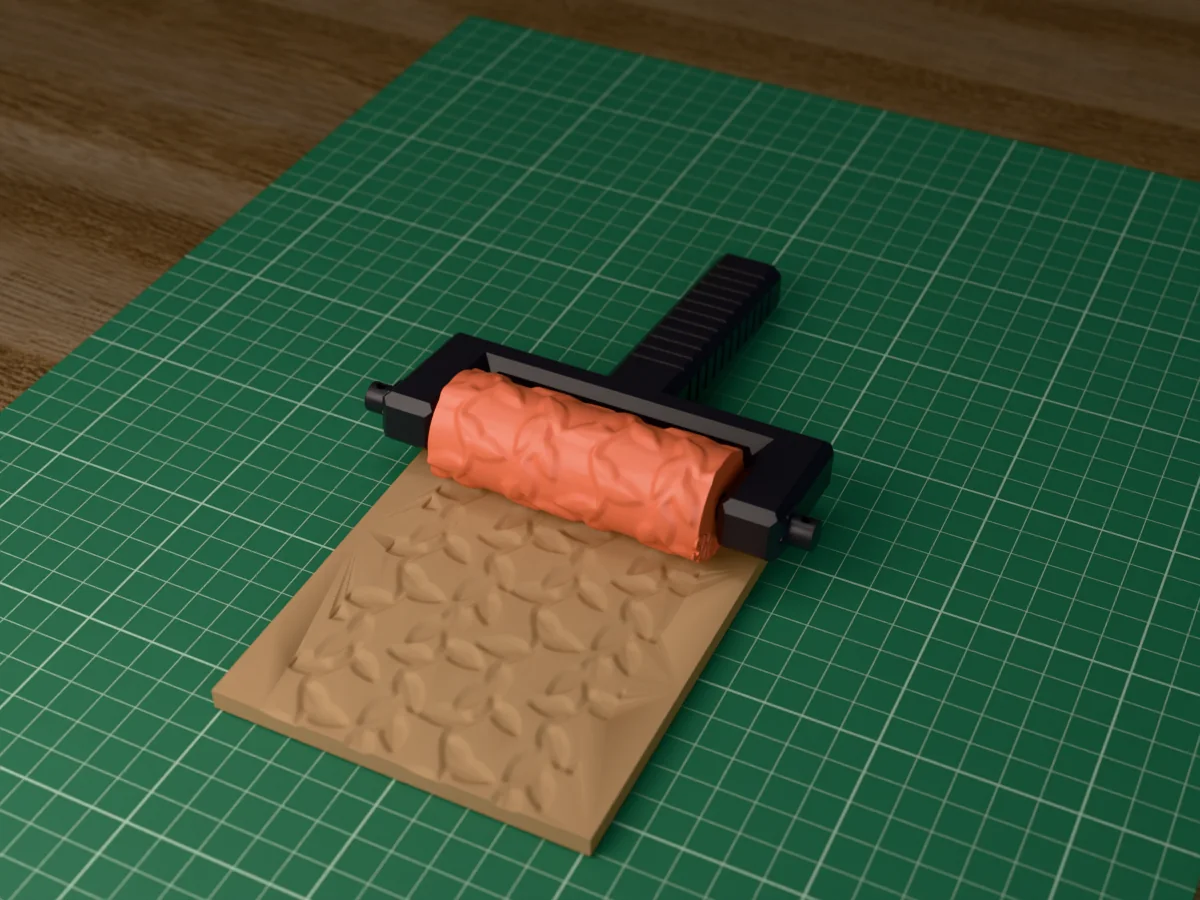 3D render of the printed leaf vine texture roller in its dark fork handle, resting on a slab of clay it has pressed with leafy vines