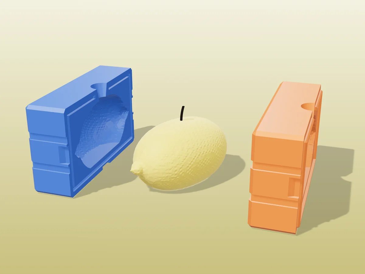 3D render of a yellow lemon candle lying on its side between the two printed halves of its rigid blue and orange mold