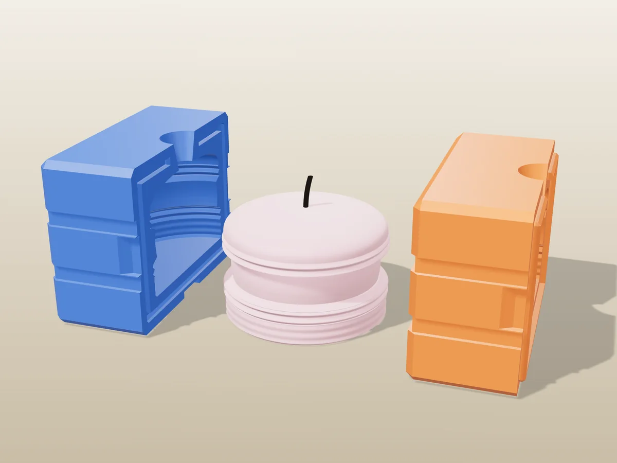 3D render of a pink macaron candle between the two printed halves of its rigid blue and orange mold
