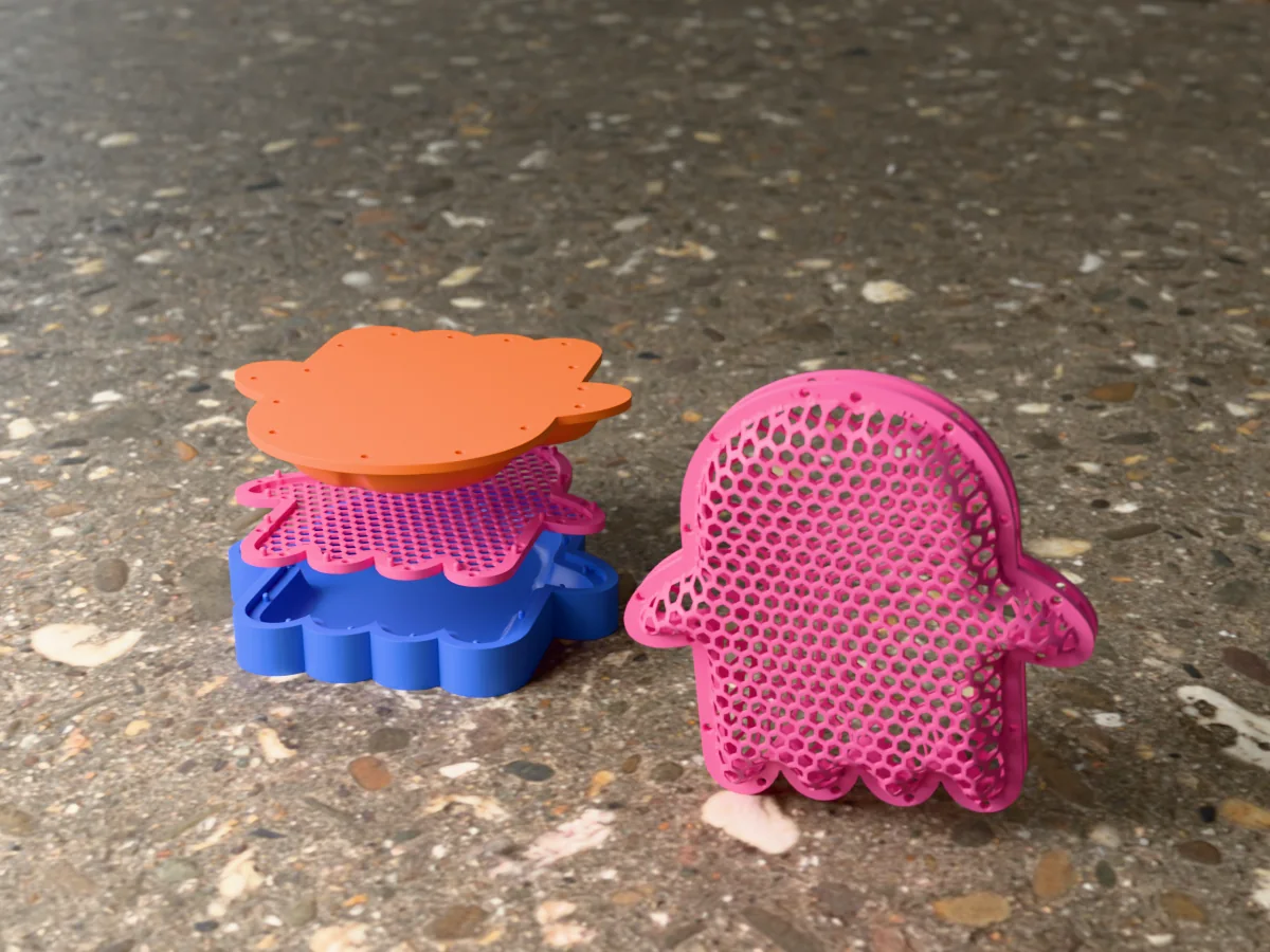 3D render of a pink honeycomb-mesh ghost with a hanging hole on its head, beside the blue cavity, the flat net and the orange plug of the press that forms it