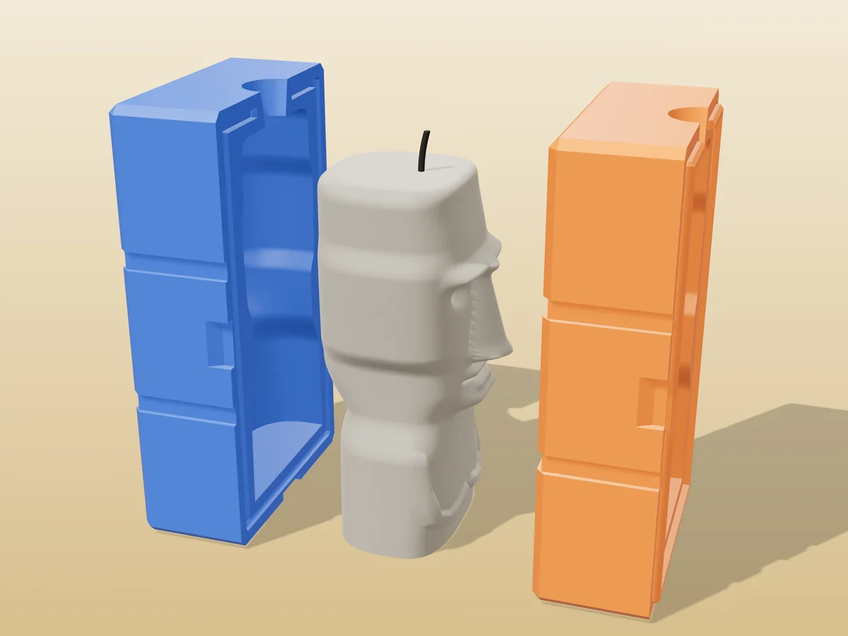 3D render of a stone grey Moai head candle between the two printed halves of its rigid orange and blue mold