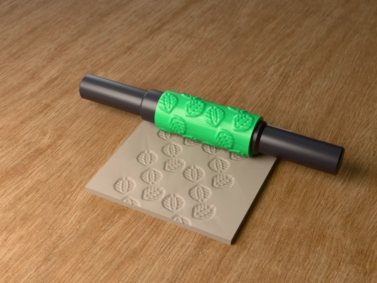 3D render of the printed monstera leaf textured rolling pin, its patterned sleeve between two dark handles, resting on a slab of clay it has pressed with monstera leaves