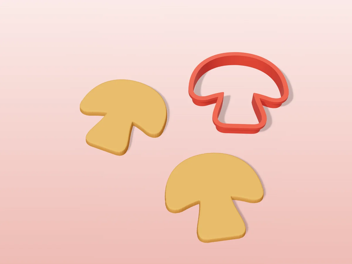 3D render of a red 3D-printed mushroom cookie cutter next to two golden baked cookies in the same shape