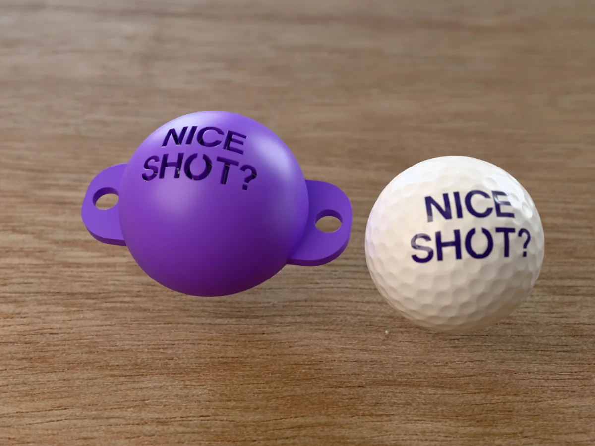 3D render of a purple 3D-printed golf ball stencil with NICE SHOT? cut through it, sitting on a golf ball, next to a ball marked with NICE SHOT? in purple