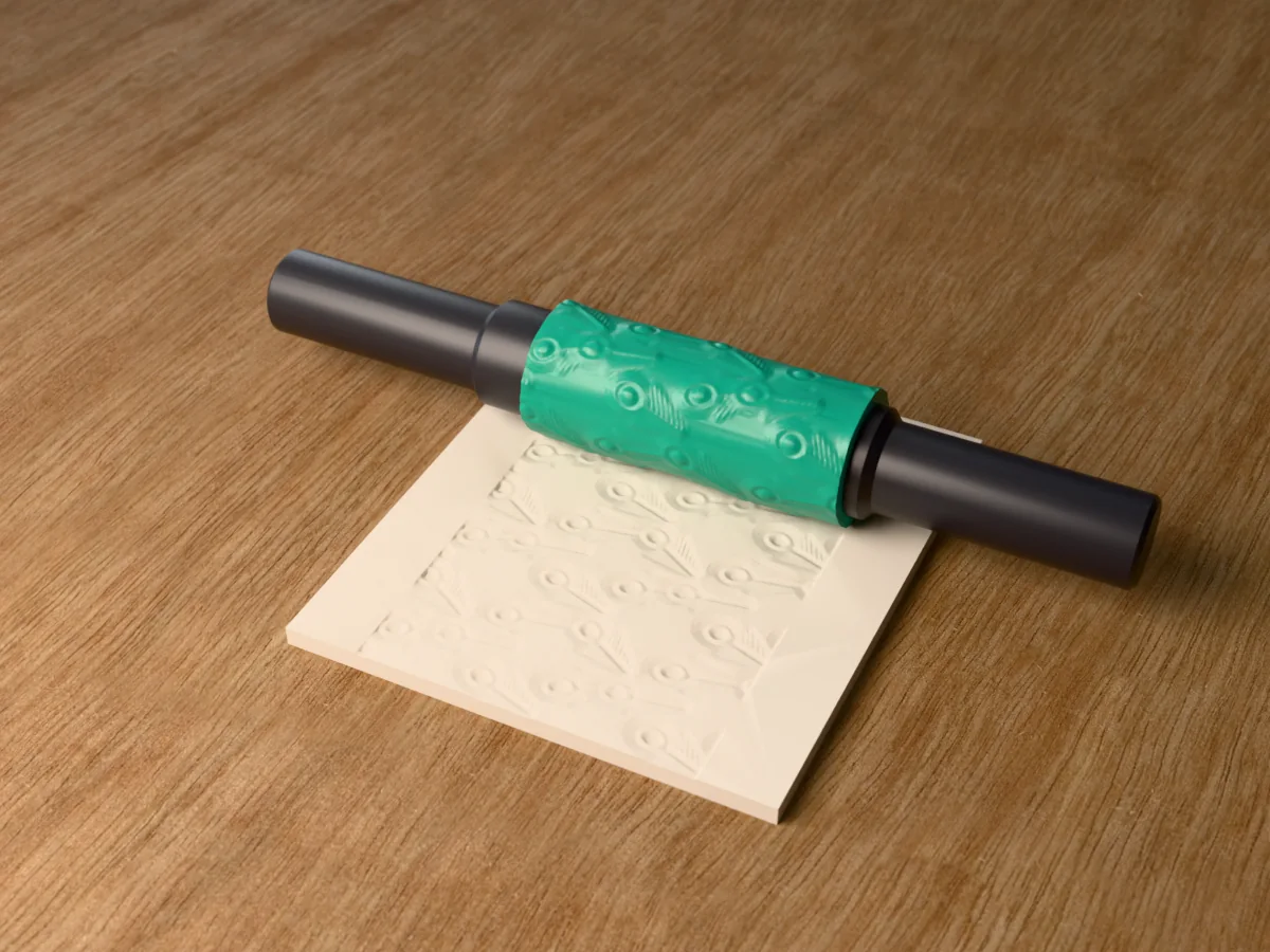 3D render of the printed peacock feather textured rolling pin, its patterned sleeve between two dark handles, resting on a slab of clay it has pressed with peacock feathers
