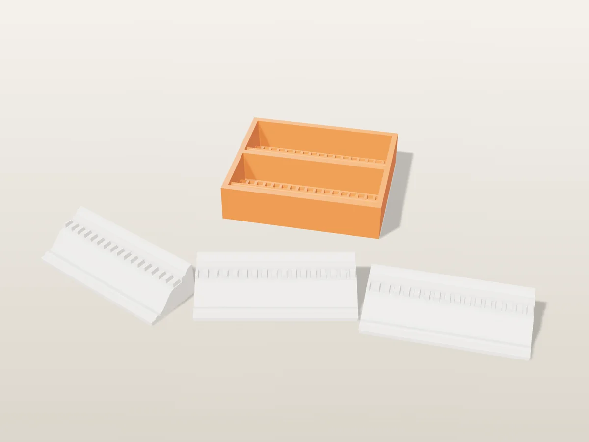 3D render of a printed orange tray with two cornice cavities, and white plaster cornice lengths with dentils in front
