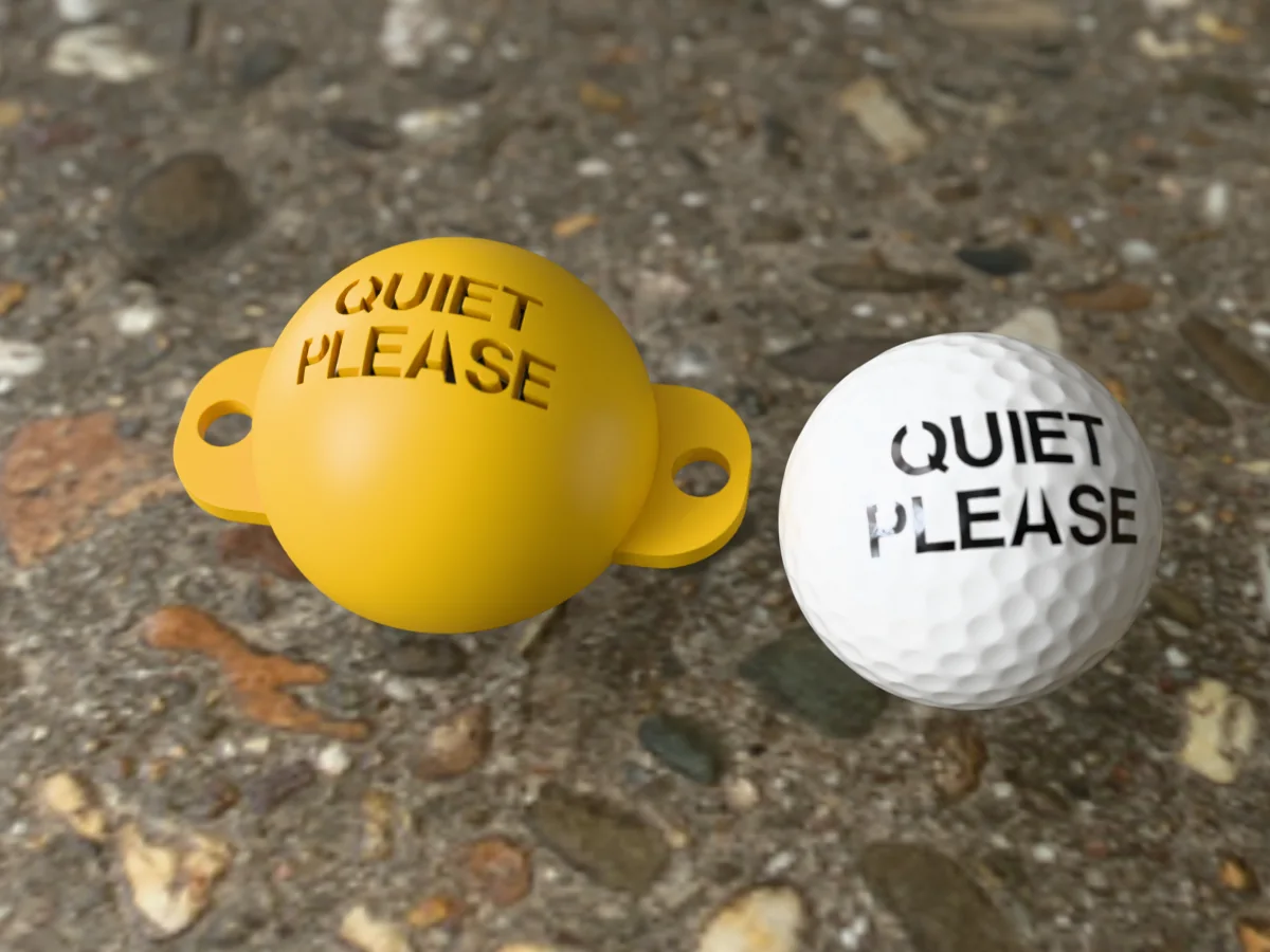 3D render of a gold 3D-printed golf ball stencil with QUIET PLEASE cut through it, sitting on a golf ball, next to a ball marked with QUIET PLEASE in black