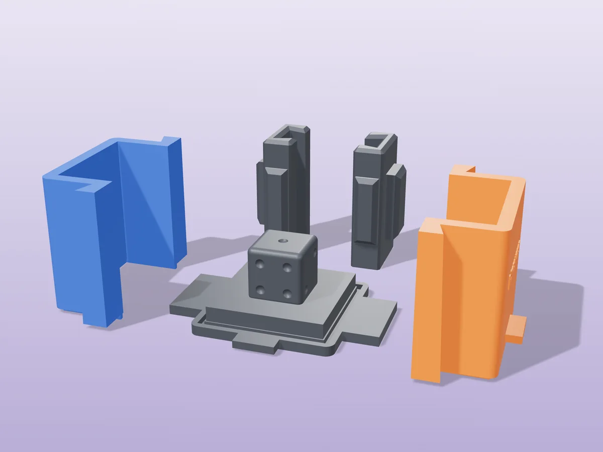 3D render of the six-sided die master with dimpled pips fused on its printed charcoal base, between the orange and blue walls, with the charcoal clamps behind