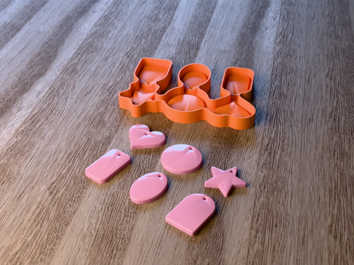 3D render of the printed caster for a six-shape resin keychain mold, with pink resin heart, circle, star, dog tag, oval and arch keychain blanks in front