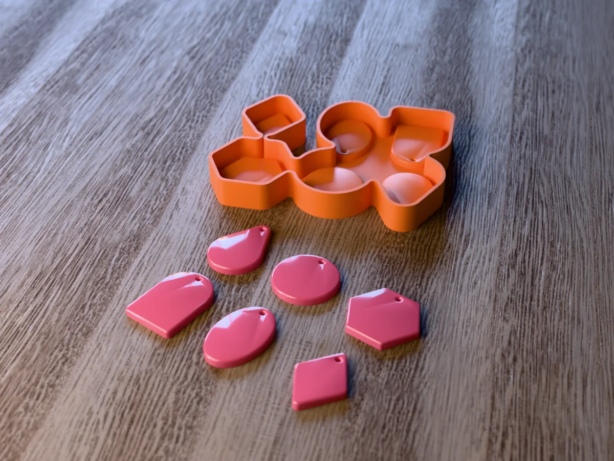 3D render of the printed caster for a resin pendant mold with six shapes, and six glossy pink resin pendant blanks with small holes in front