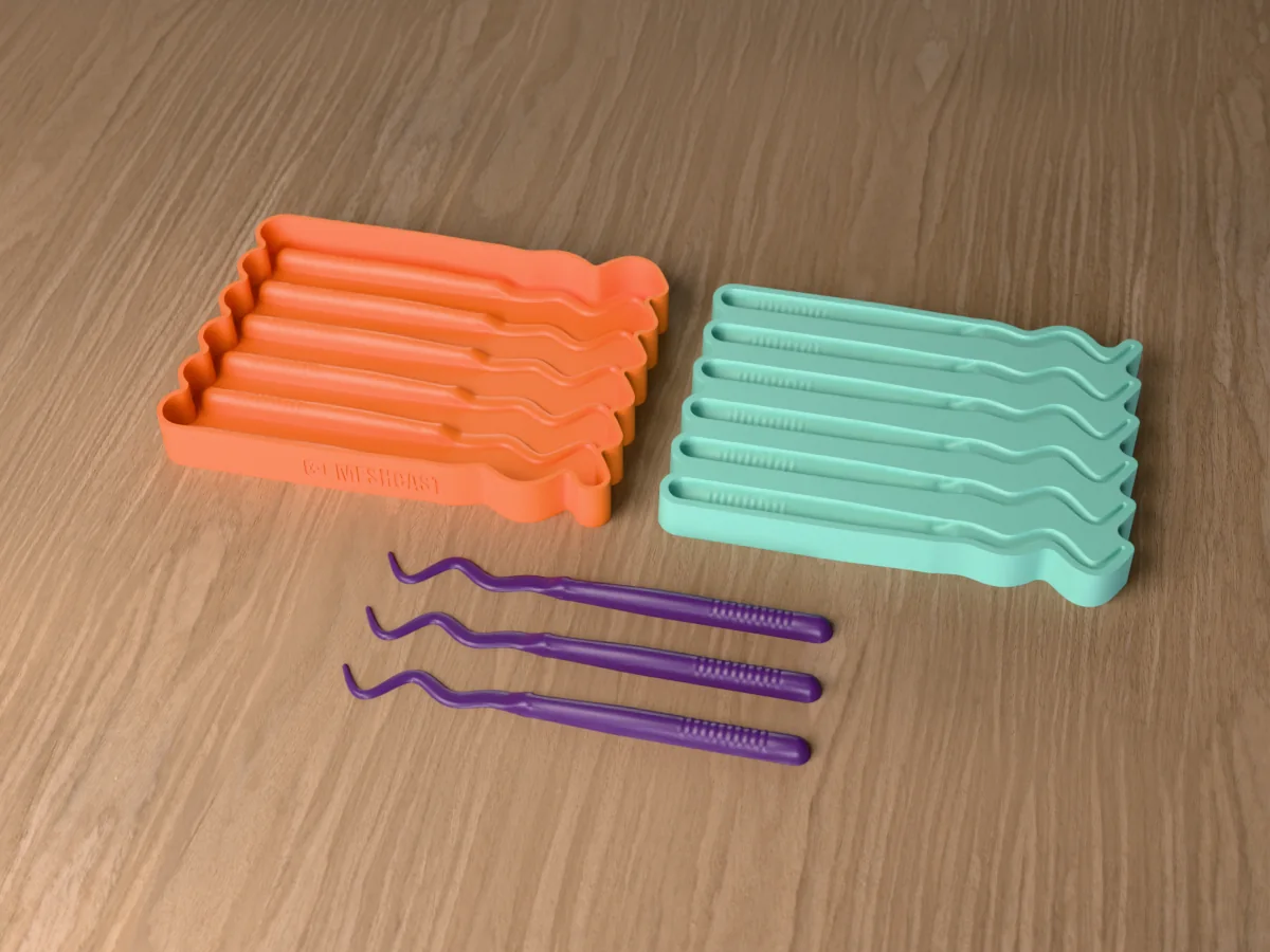 3D render of the printed caster for a six-cavity silicone ribbon tail worm lure mold beside the silicone mold it pours, with purple soft plastic ribbon tail worms in front