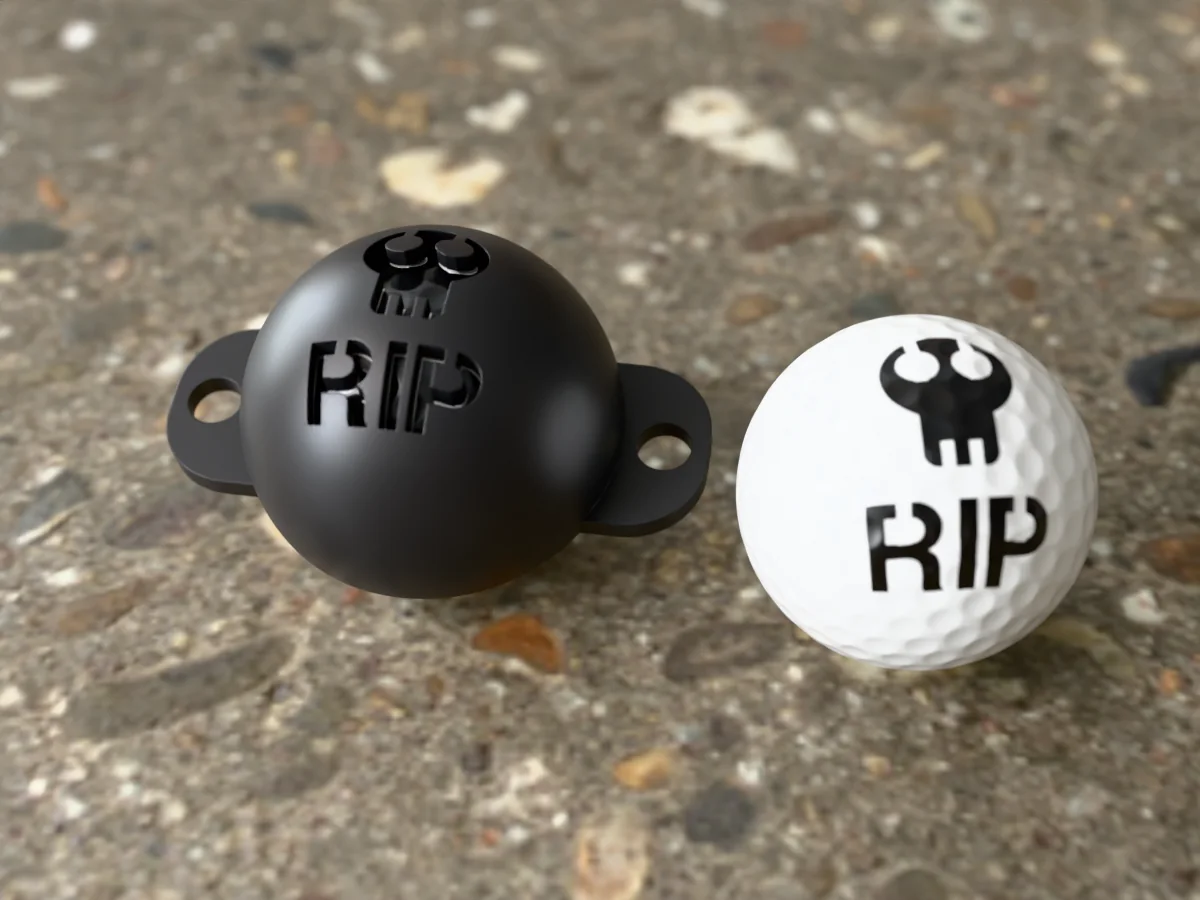 3D render of a black 3D-printed golf ball stencil with a skull over RIP cut through it, sitting on a golf ball, next to a ball marked with a skull over RIP in black