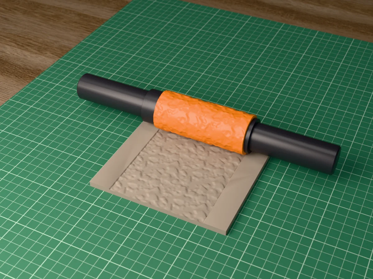 3D render of the printed rubble and scree textured rolling pin, its patterned sleeve between two dark handles, resting on a slab of clay it has pressed with rubble and scree
