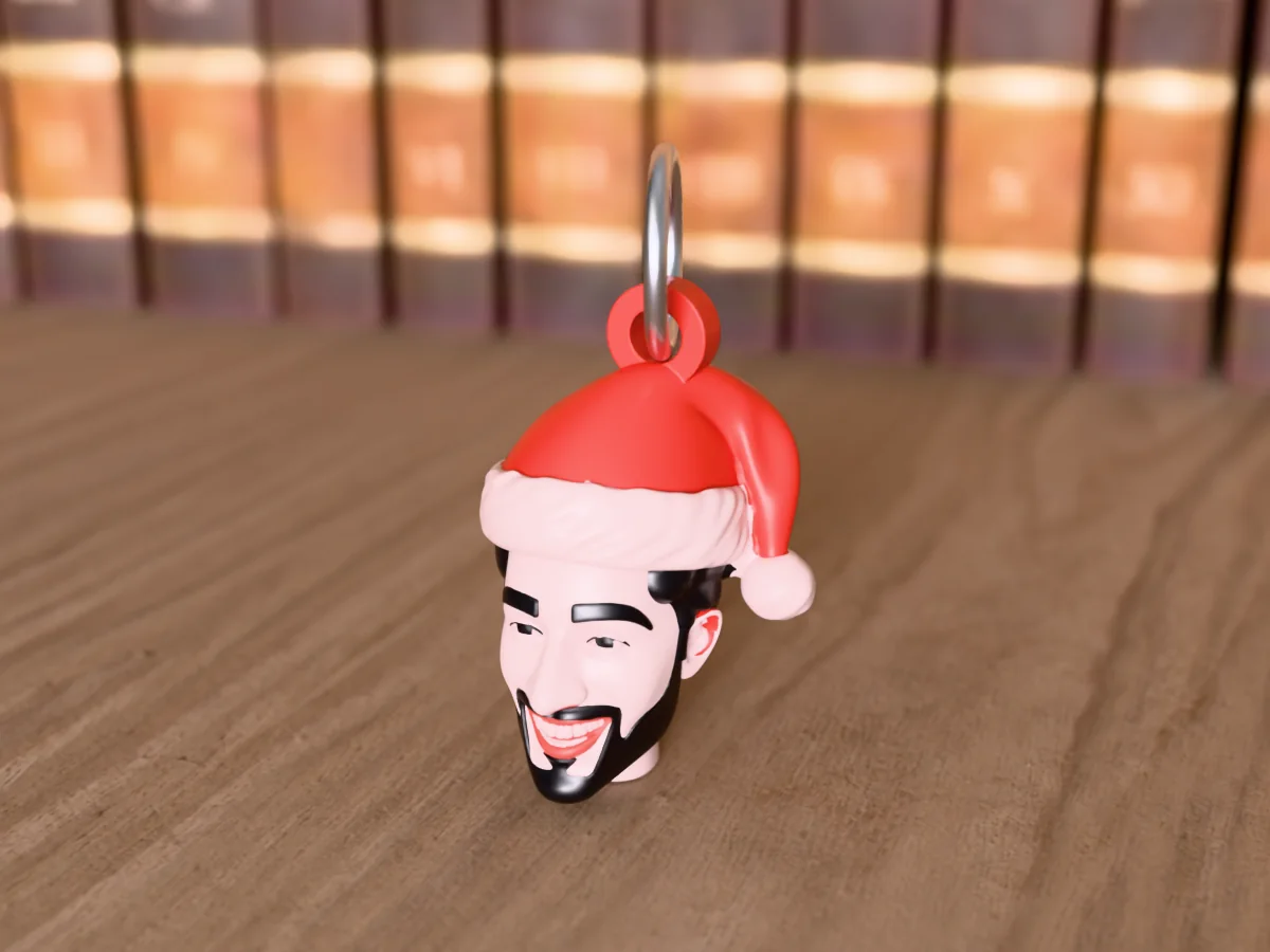 3D render of a 3D-printed head keychain of a guy with a black beard in a Santa hat, painted in 6 colours, on a table