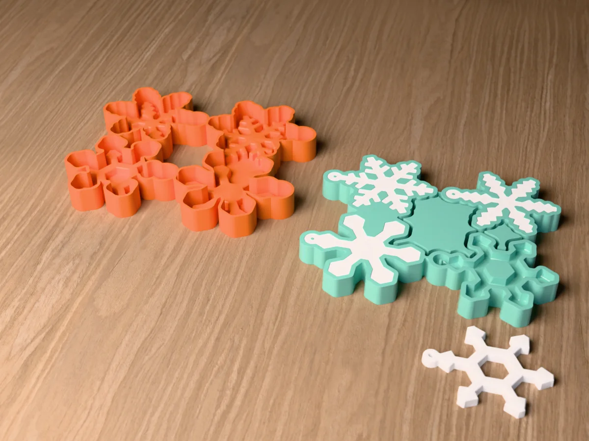 3D render of the printed caster for a snowflake ornament mold beside its silicone mold, with white plaster snowflake ornaments