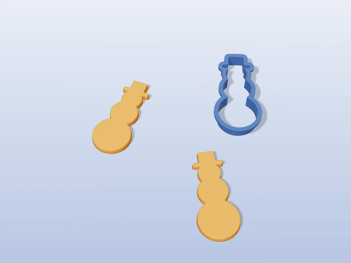 3D render of a navy blue 3D-printed snowman cookie cutter next to two golden baked cookies in the same shape