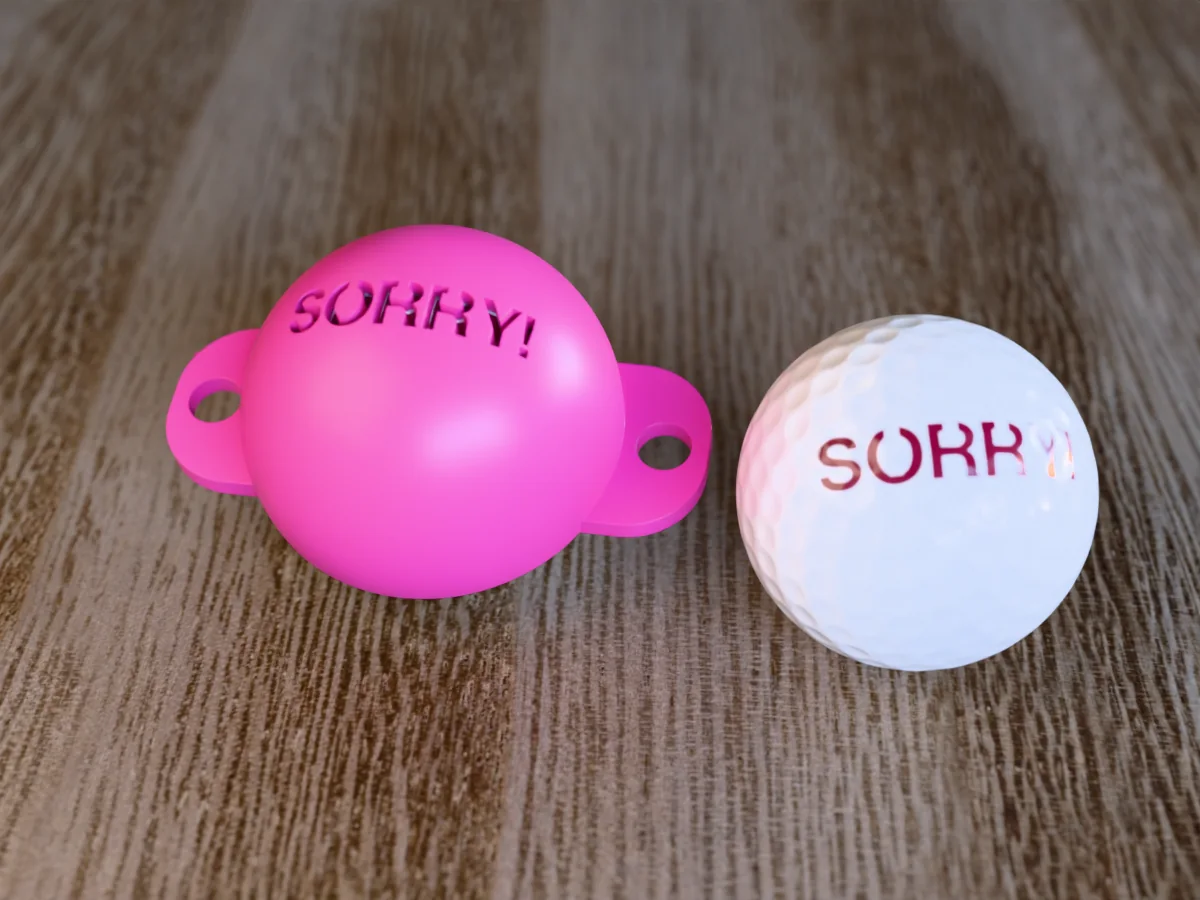 3D render of a pink 3D-printed golf ball stencil with SORRY! cut through it, sitting on a golf ball, next to a ball marked with SORRY! in magenta