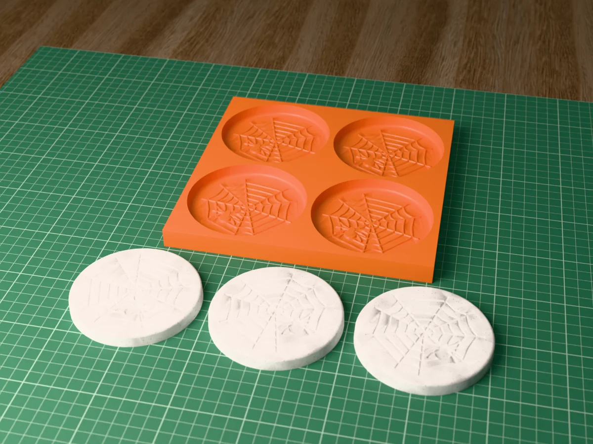3D render of a printed orange tray with four spider web coaster cavities, and three grey concrete coasters with an engraved web and spider in front