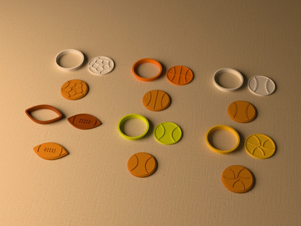 3D render of six 3D-printed sports ball cookie cutters with their stamps and a golden stamped cookie in front of each: soccer ball, basketball, baseball, American football, tennis ball and volleyball
