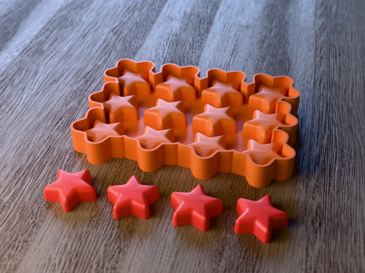3D render of the printed caster for a twelve-cavity star crayon mold, with four red chunky star crayons in front
