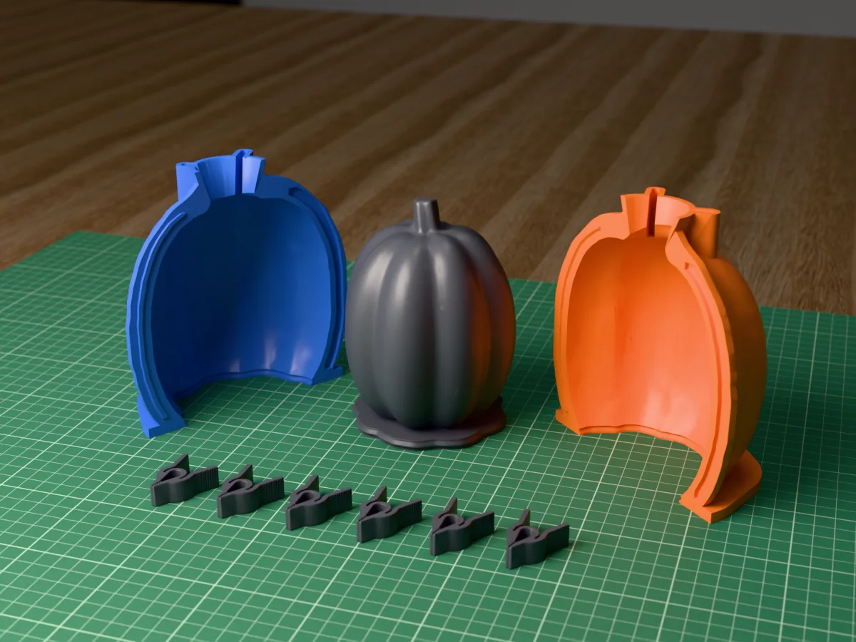 3D render of the tall ribbed concrete pumpkin master with its stem, fused on its printed charcoal base between the orange and blue shell halves, with the charcoal clamps in front