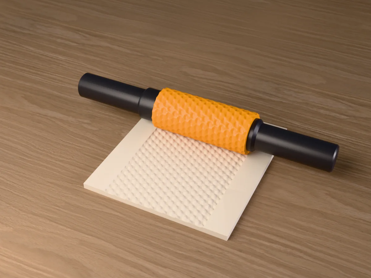 3D render of the printed tumbling block textured rolling pin, its patterned sleeve between two dark handles, resting on a slab of clay it has pressed with tumbling blocks