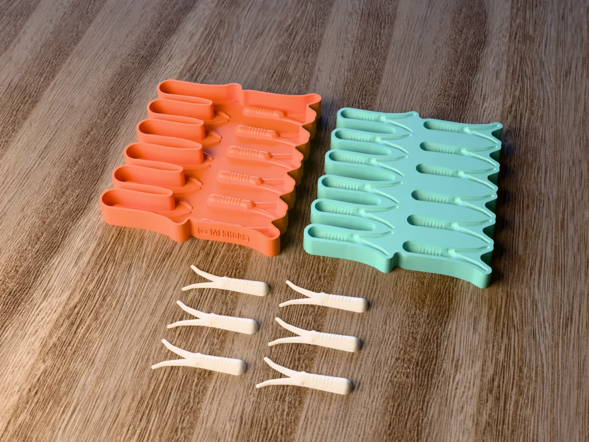 3D render of the printed caster for a twelve-cavity silicone twin tail jig trailer mold beside the silicone mold it pours, with pearl white soft plastic twin tail trailers in front