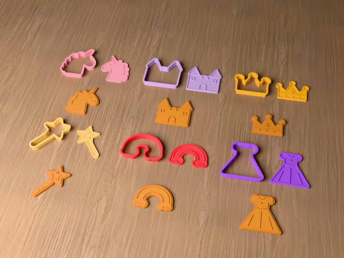 3D render of six 3D-printed unicorn and princess cookie cutters with their stamps and a golden stamped cookie in front of each: unicorn, castle, crown, magic wand, rainbow and princess dress