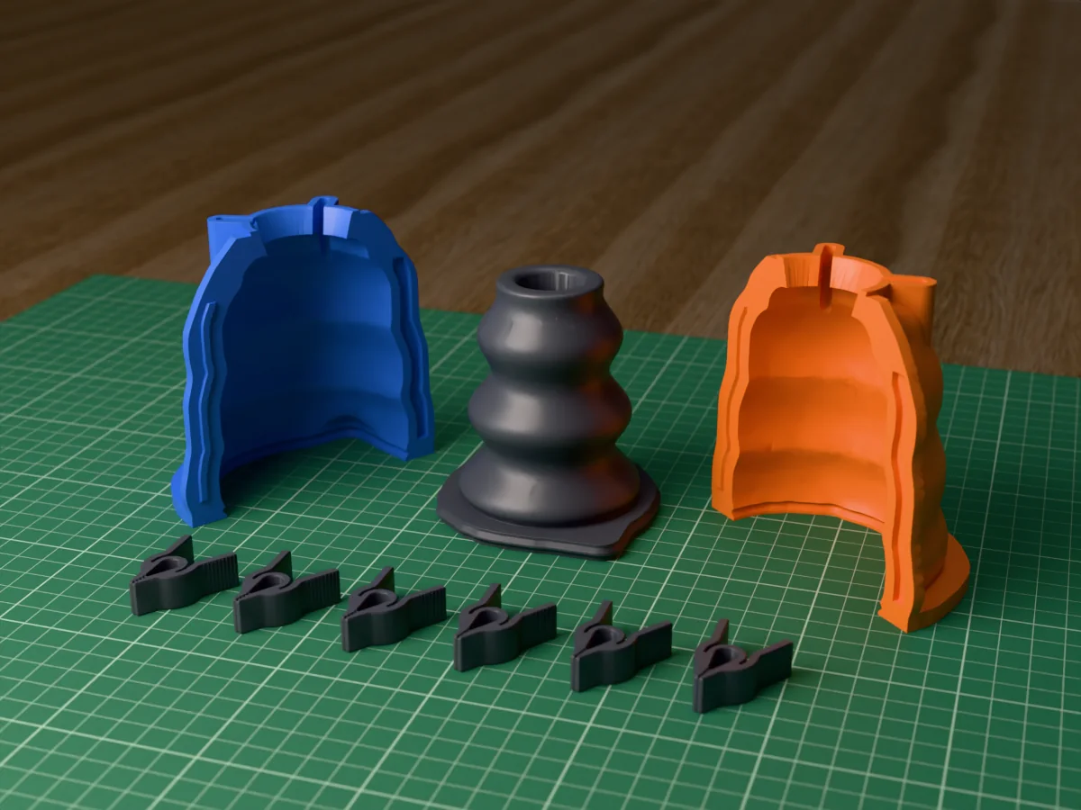 3D render of the wavy taper candle holder master, a chunky column of three soft waves with a candle socket, fused on its printed charcoal base between the orange and blue shell halves, with the charcoal clamps in front