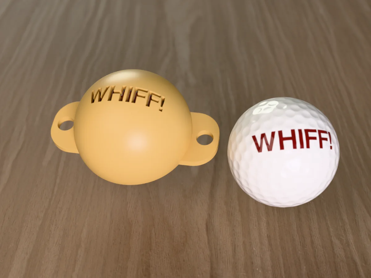 3D render of a sand 3D-printed golf ball stencil with WHIFF! cut through it, sitting on a golf ball, next to a ball marked with WHIFF! in brick red