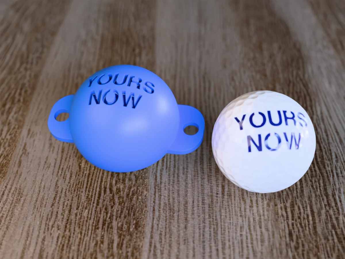 3D render of a blue 3D-printed golf ball stencil with YOURS NOW cut through it, sitting on a golf ball, next to a ball marked with YOURS NOW in blue