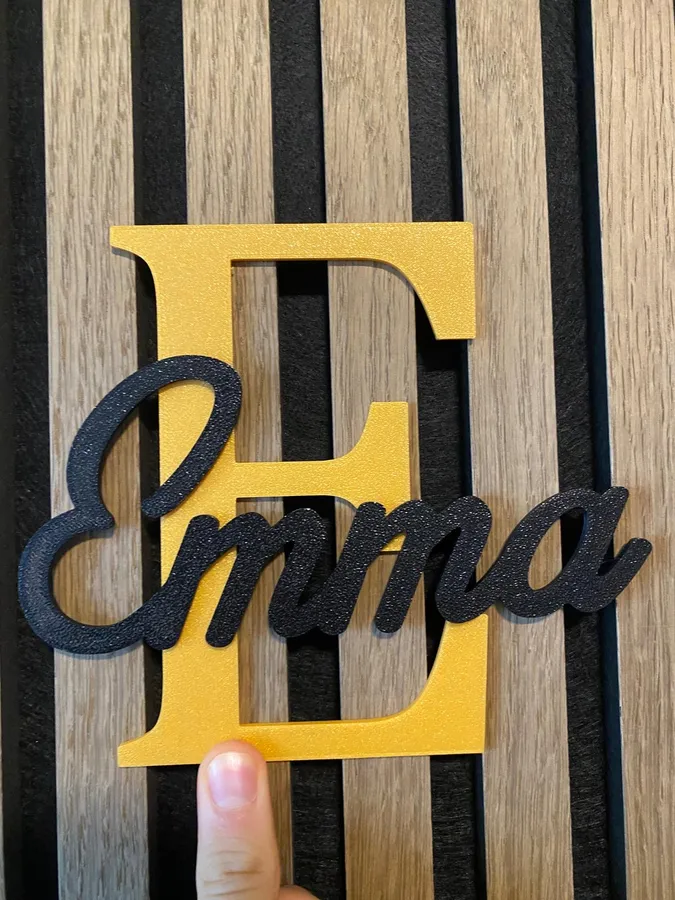A layered 'Emma' name sign, black script over a gold initial, 3D-printed with the Name sign tool