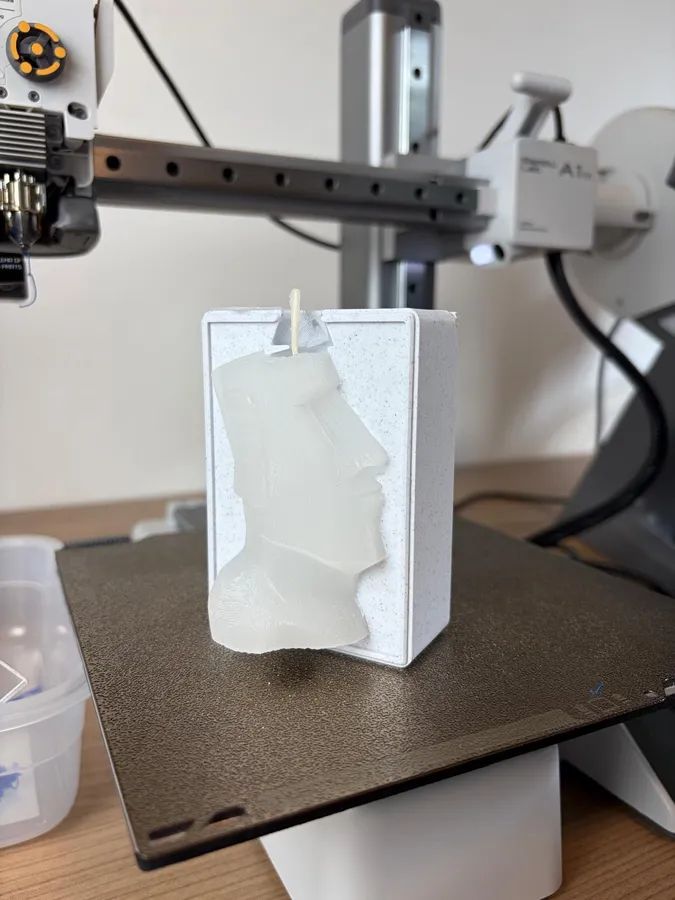 A Moai head candle in its printed mold, straight off the printer bed.